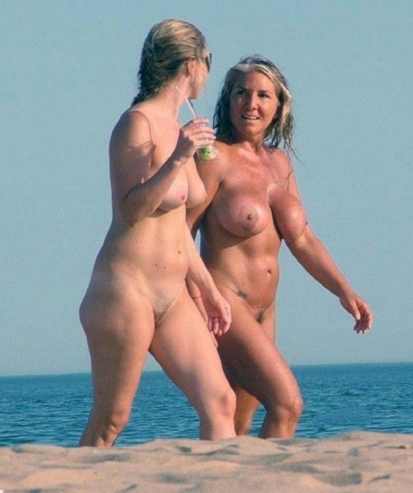 Naked mother with daughter on the beach