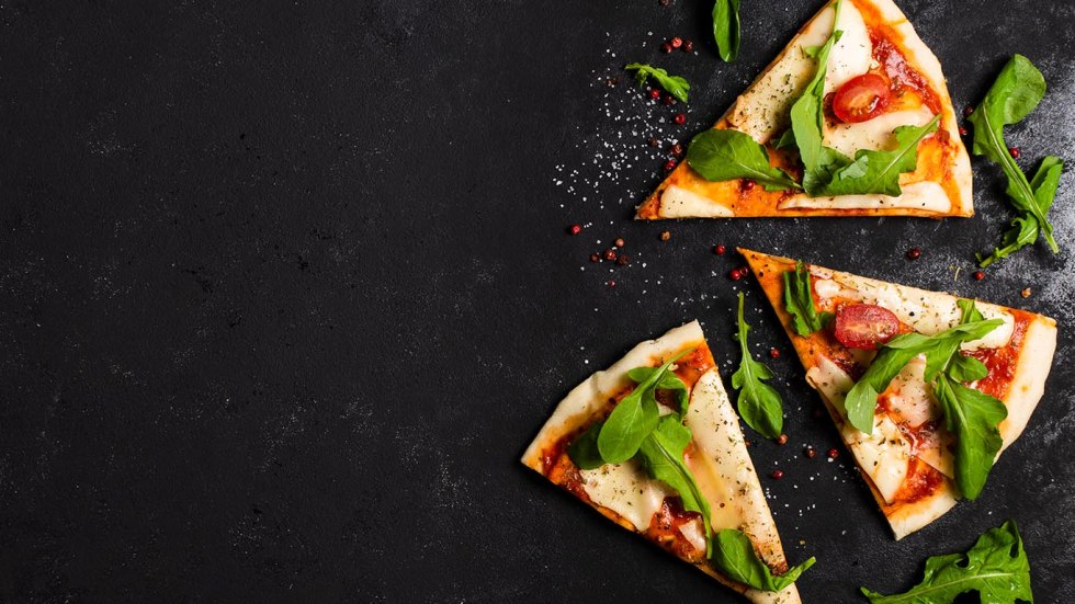A piece of pizza on a black background