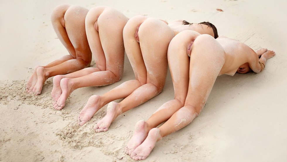 Four naked butt in the sand