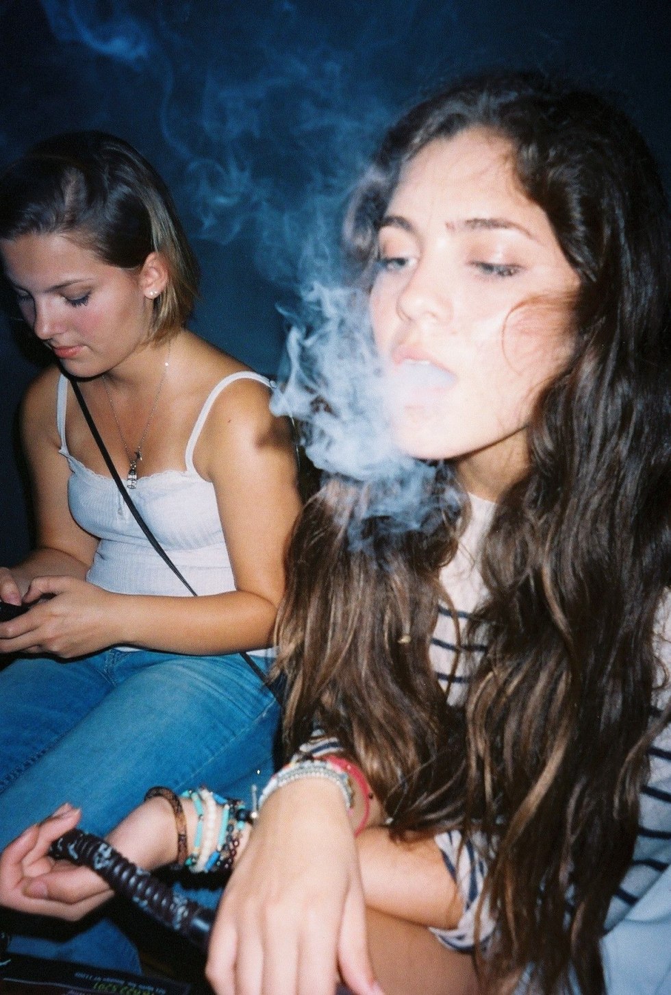 The girl smokes at a party