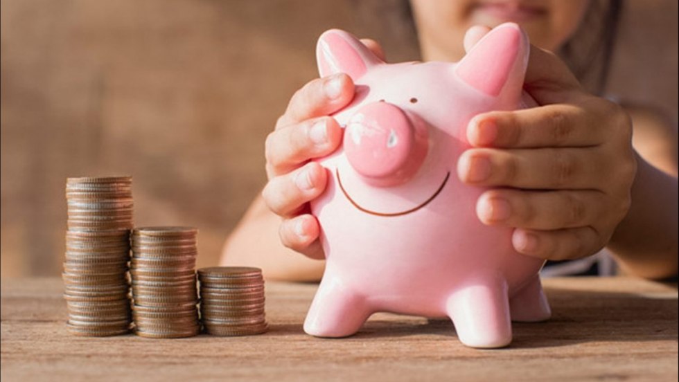 Woman puts money in a piggy bank