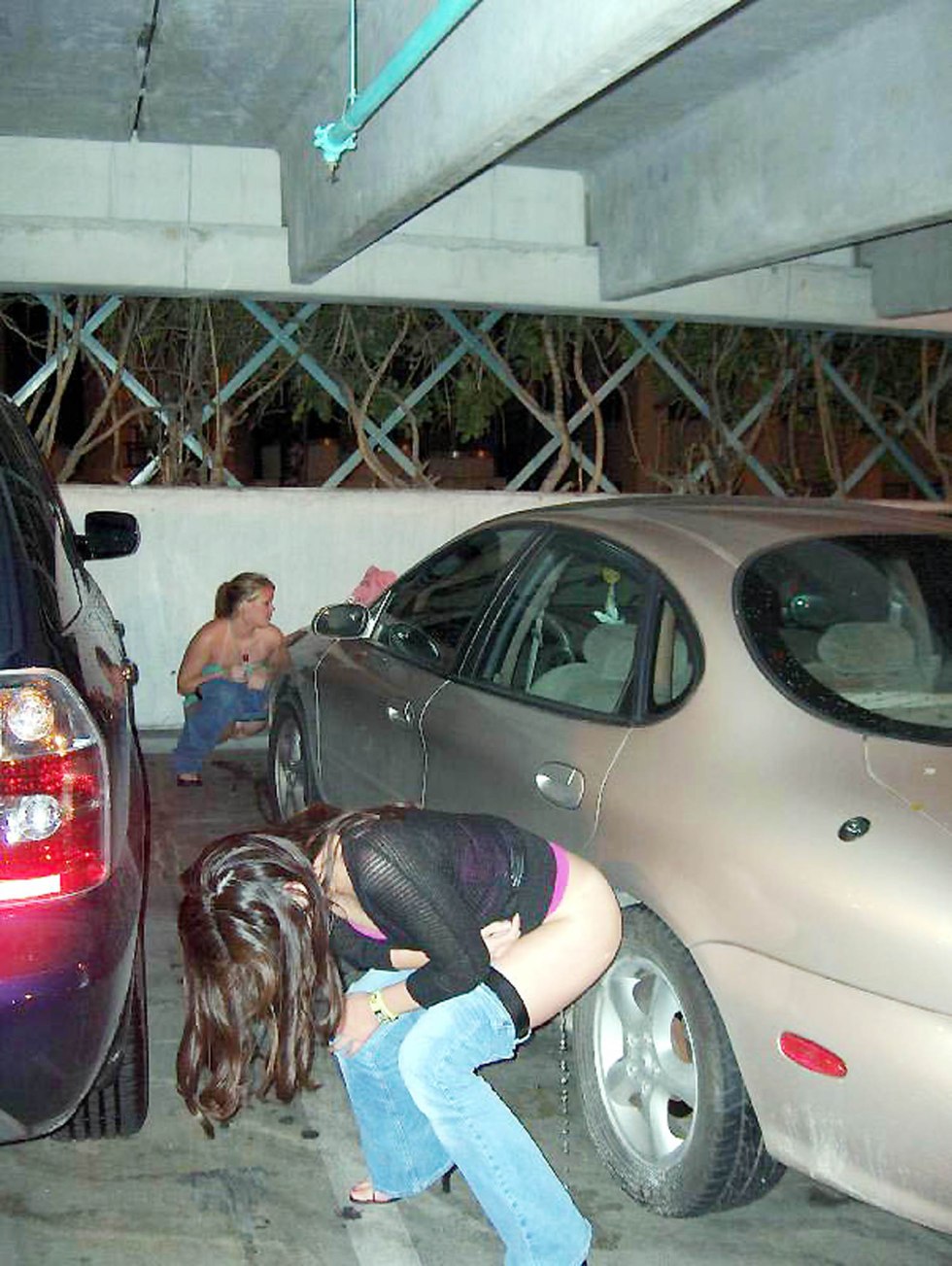 The girl pisses near the car
