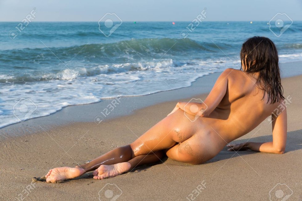 Naked Girl On Beach Laying on Her Stomach Feet Up