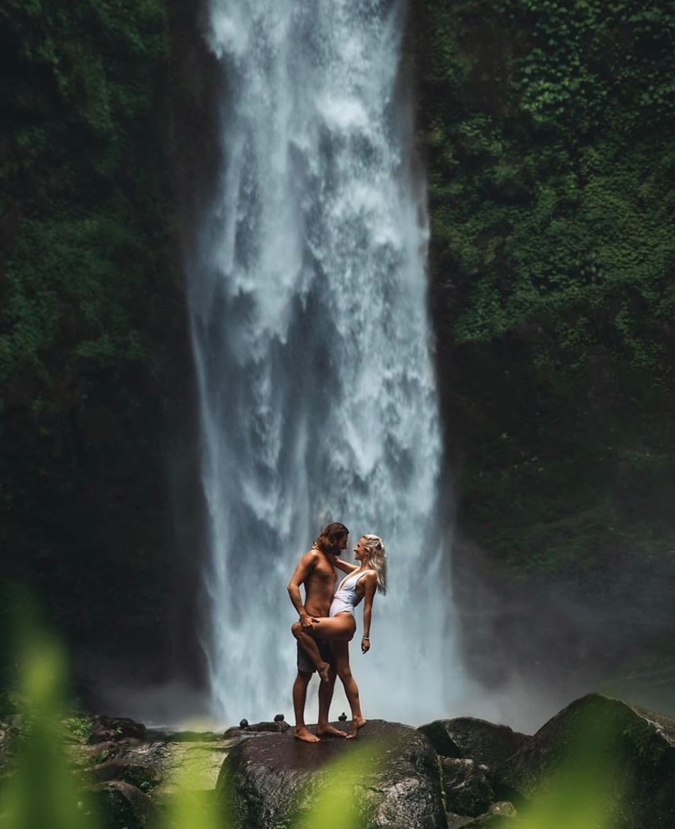 Naked guys under a waterfall