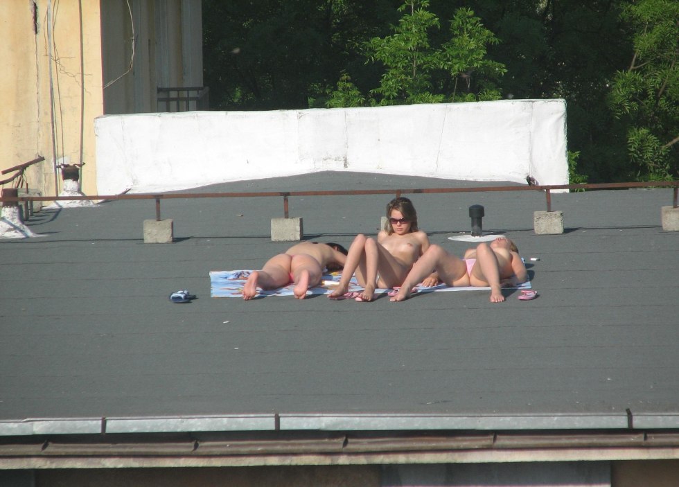 Girls sunbathe on the roof nude