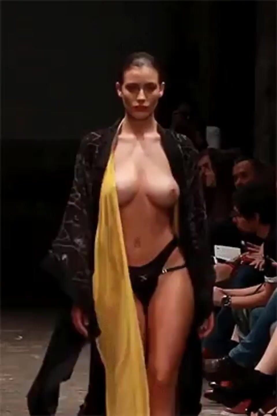 Models on the catwalk with bare breasts