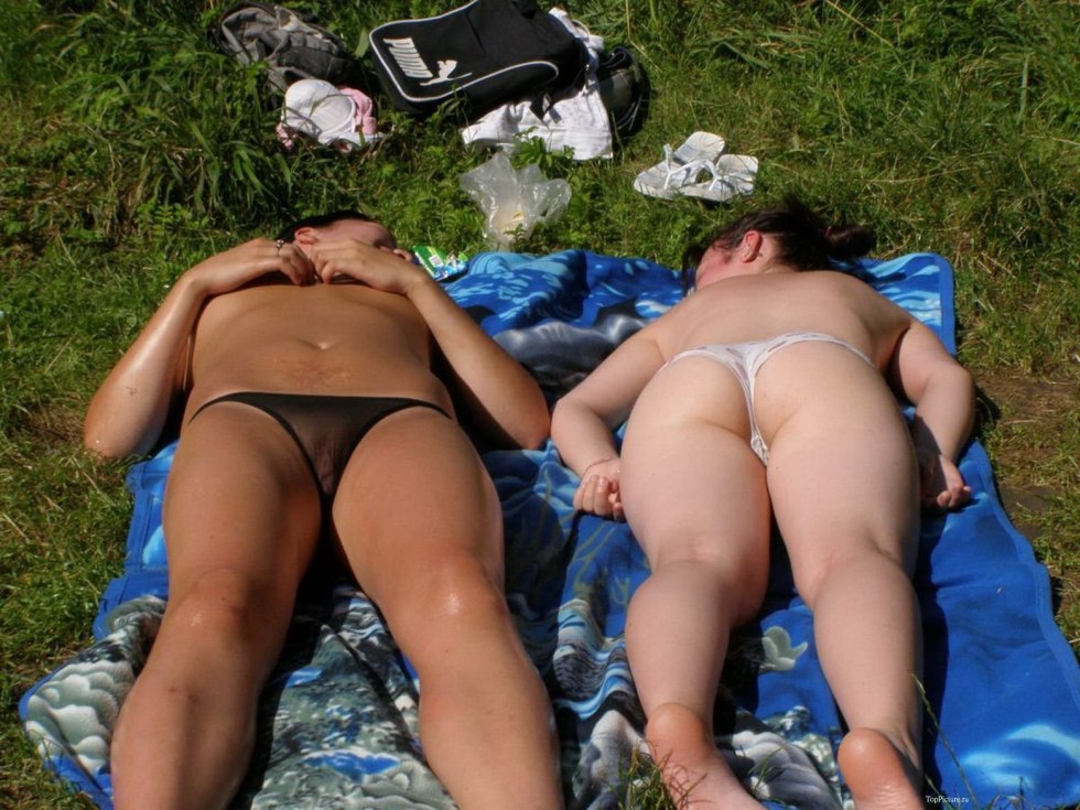 The wife sunbathes in transparent panties on the beach
