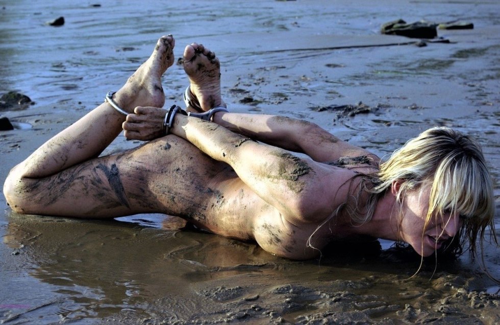 Naked women in mud on the beach