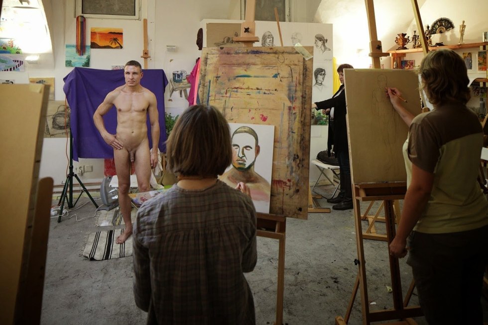 A naked man poses an artist