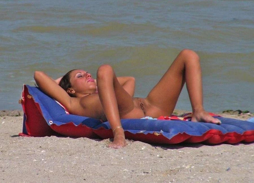 On the beach, the girls sunbathe without panties