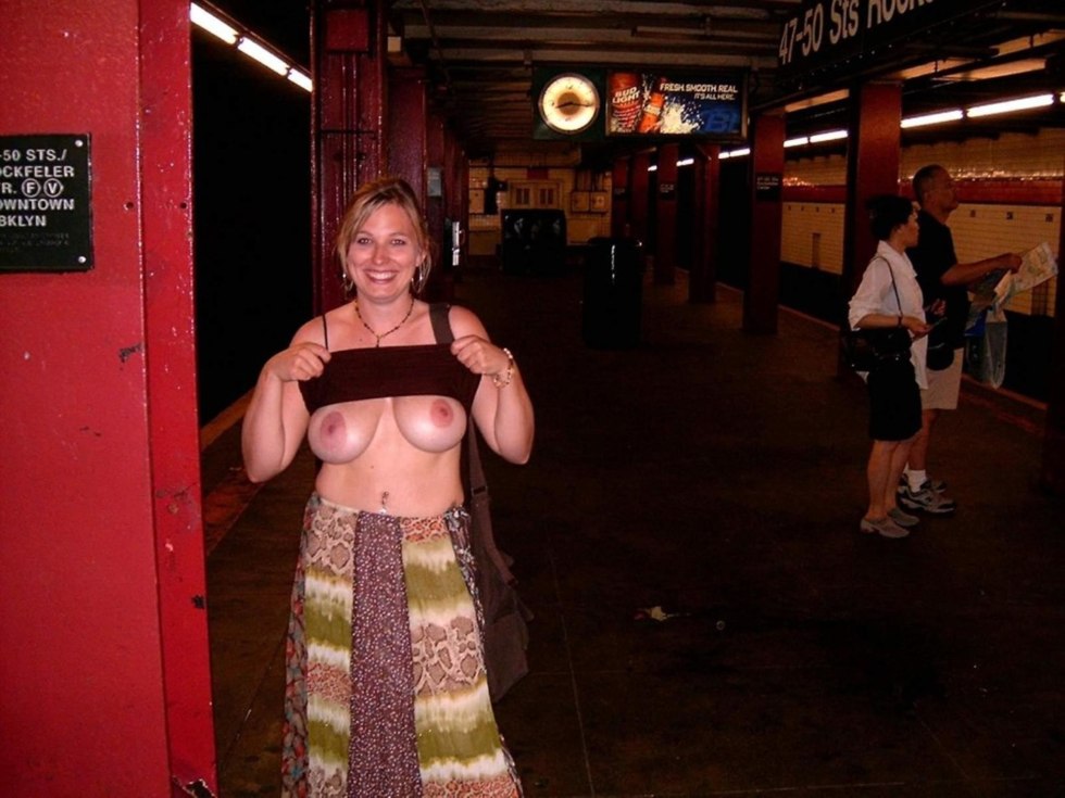 The girl shows her breasts in a public place