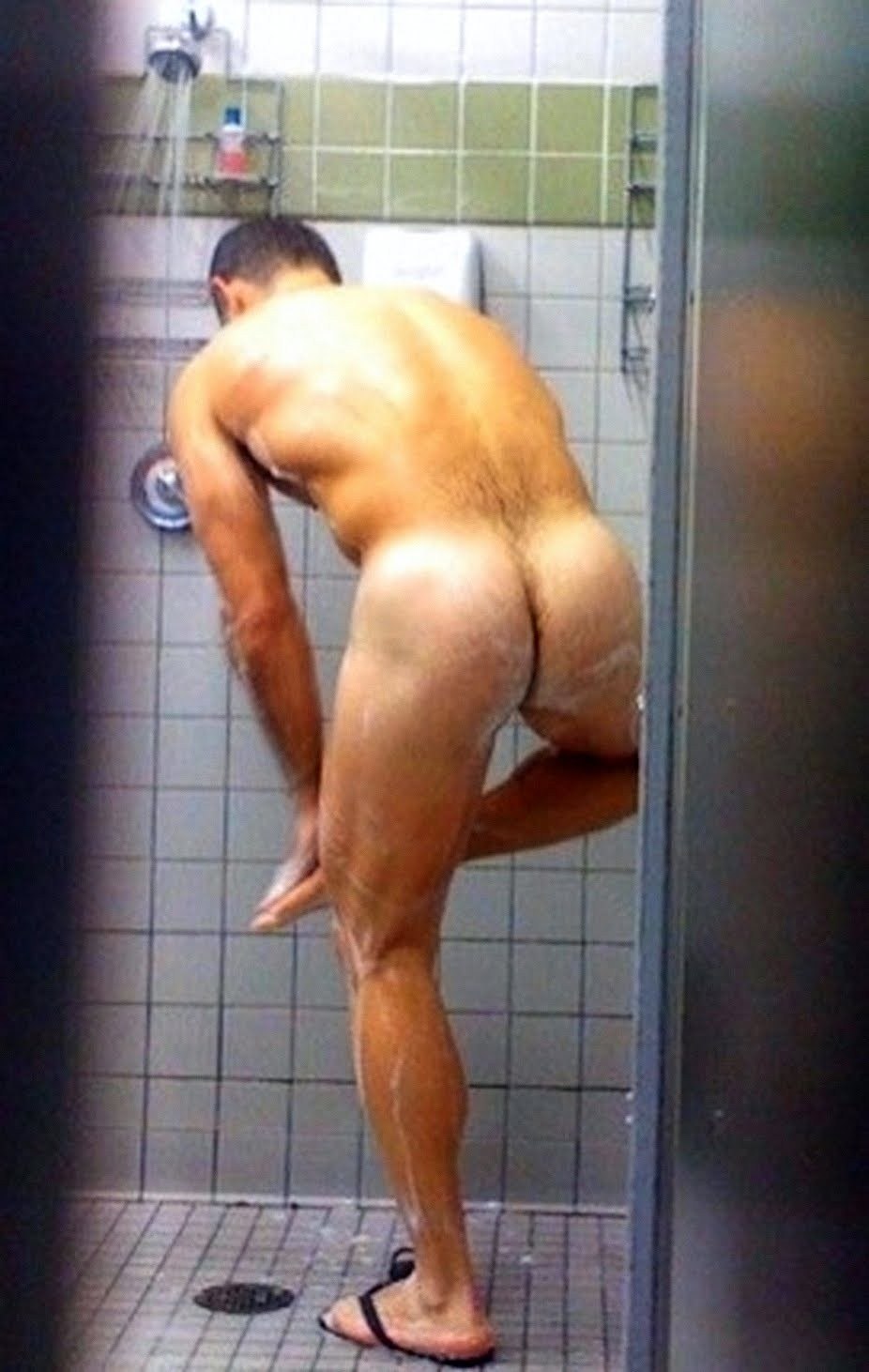 A naked man washes in the shower