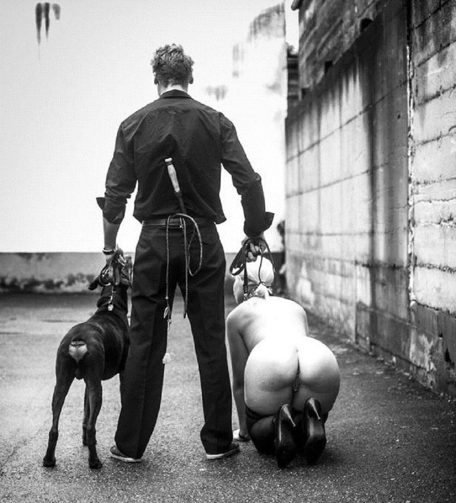 BDSM woman in a collar on leashes