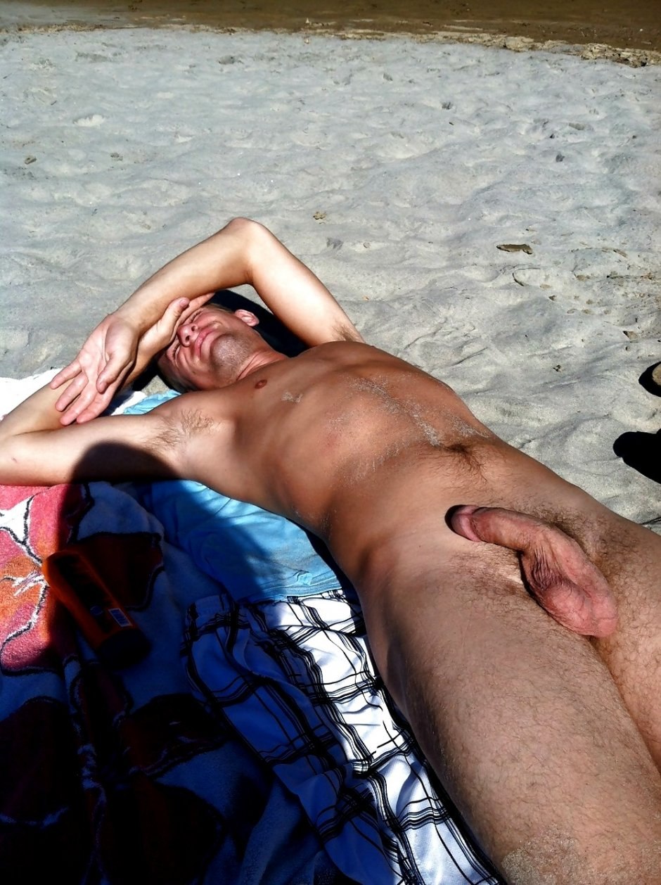 Naked men sunbathe on the beach