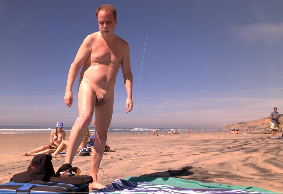Naked man with a small member on the beach