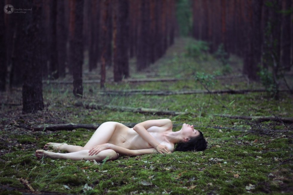 Naked woman lies in the forest