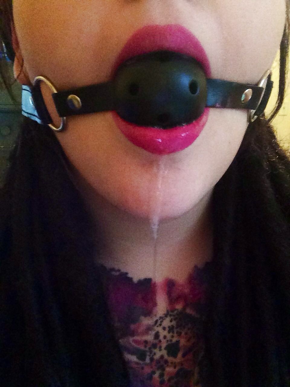 Girl with a gag in the mouth of saliva