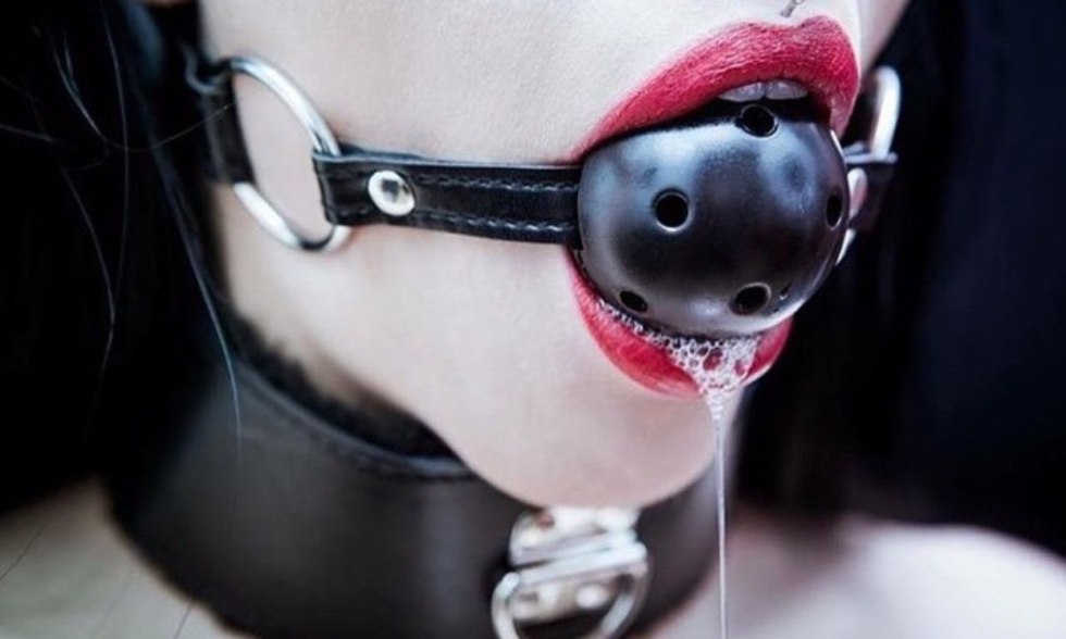 Girl with a ball in the mouth of BDSM