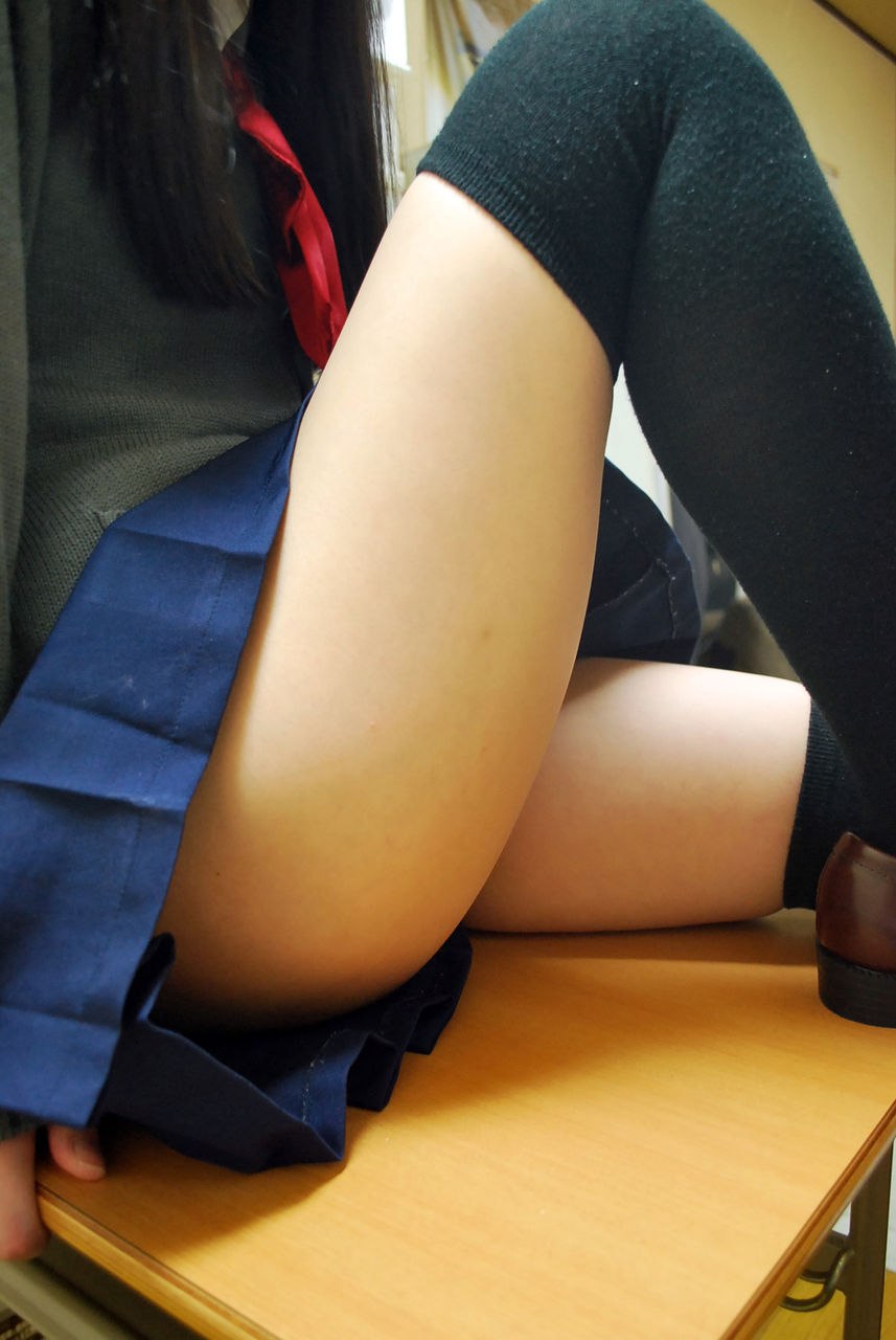 Schoolgirl legs under the desktop