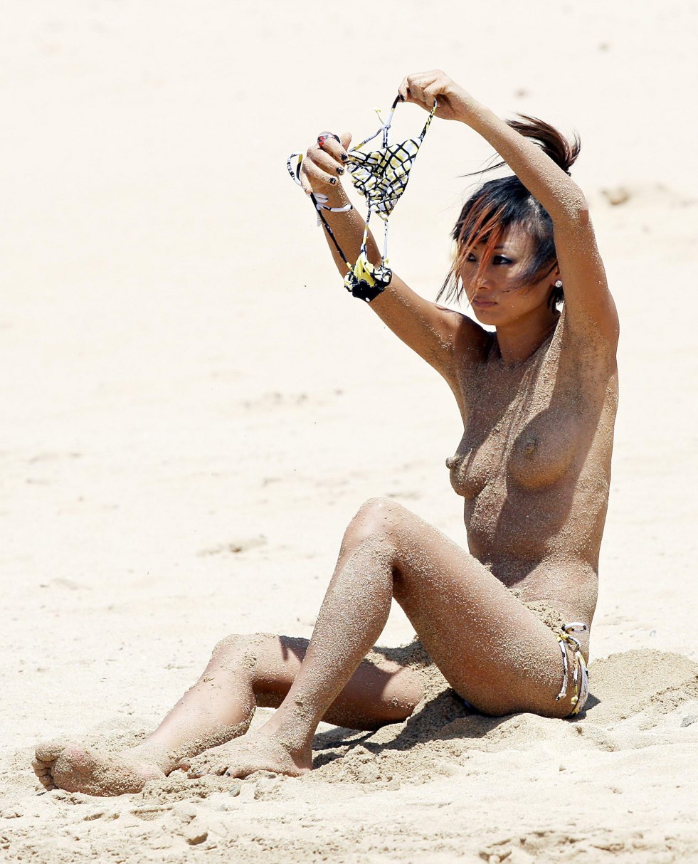 Bai Lin covers her chest on the beach