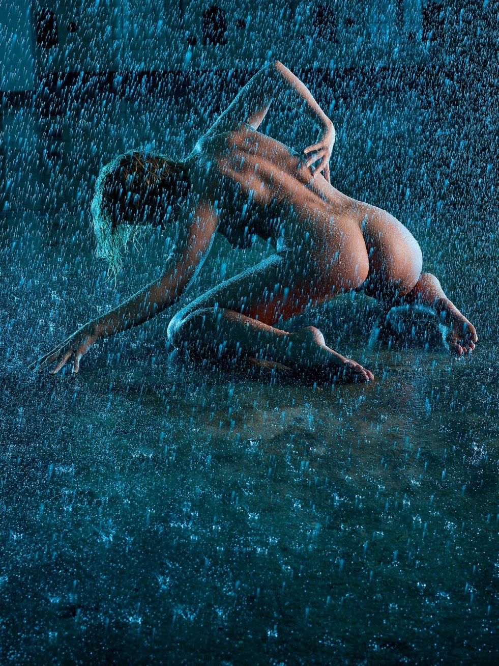 The girl lies in the rain nude