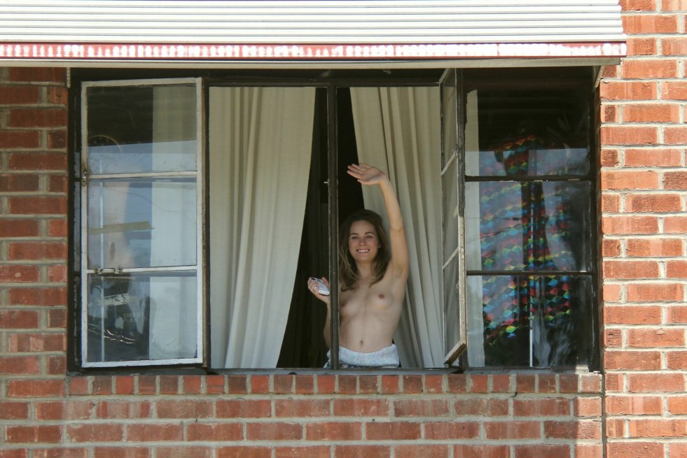 The girl shows the breast of the window