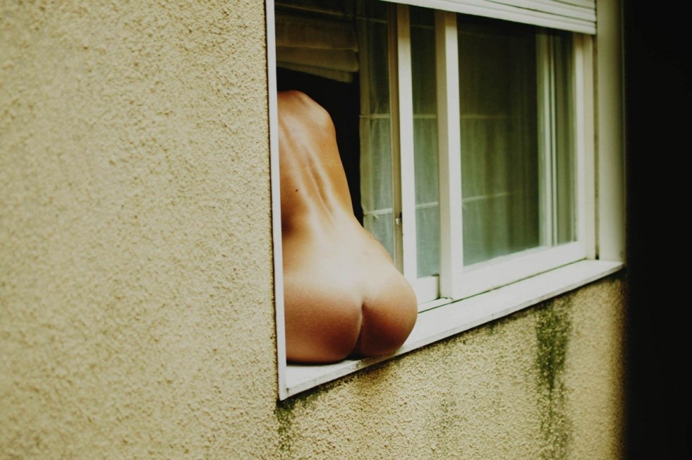 Erotic pose on the windowsill