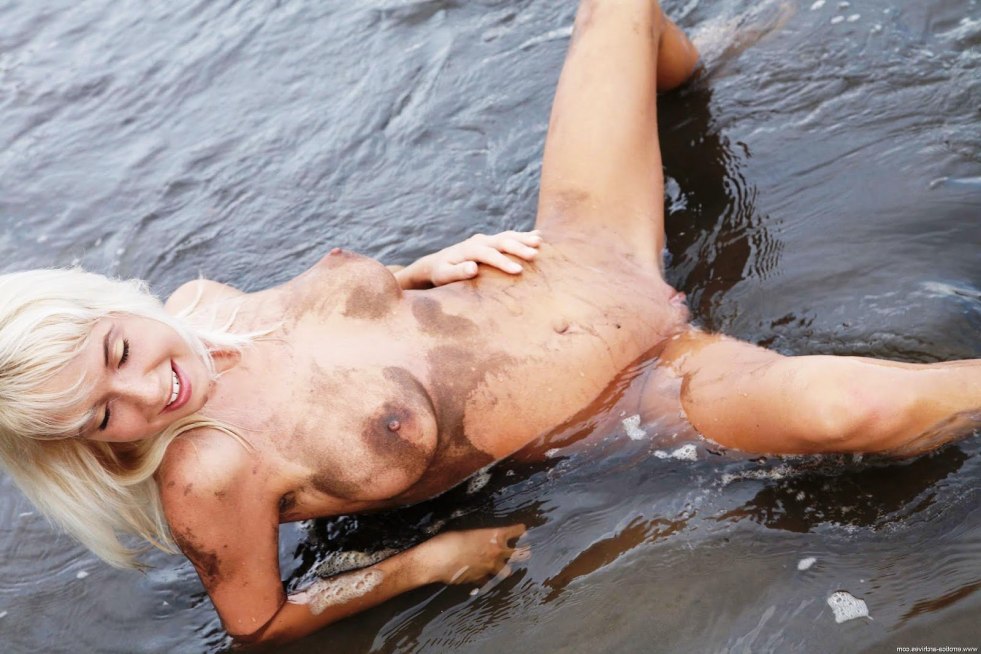 Naked women bathe in mud