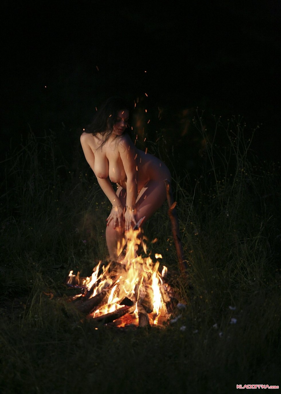 Naked woman near the fire
