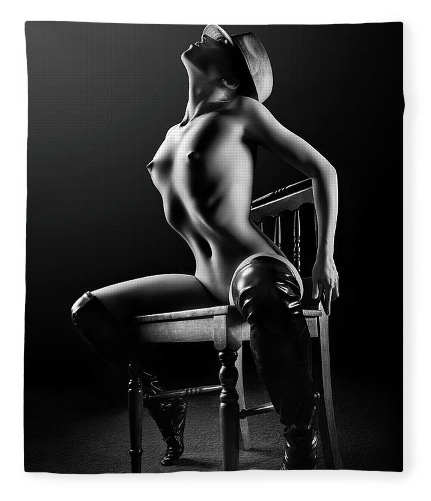 Naked woman sits in a chair