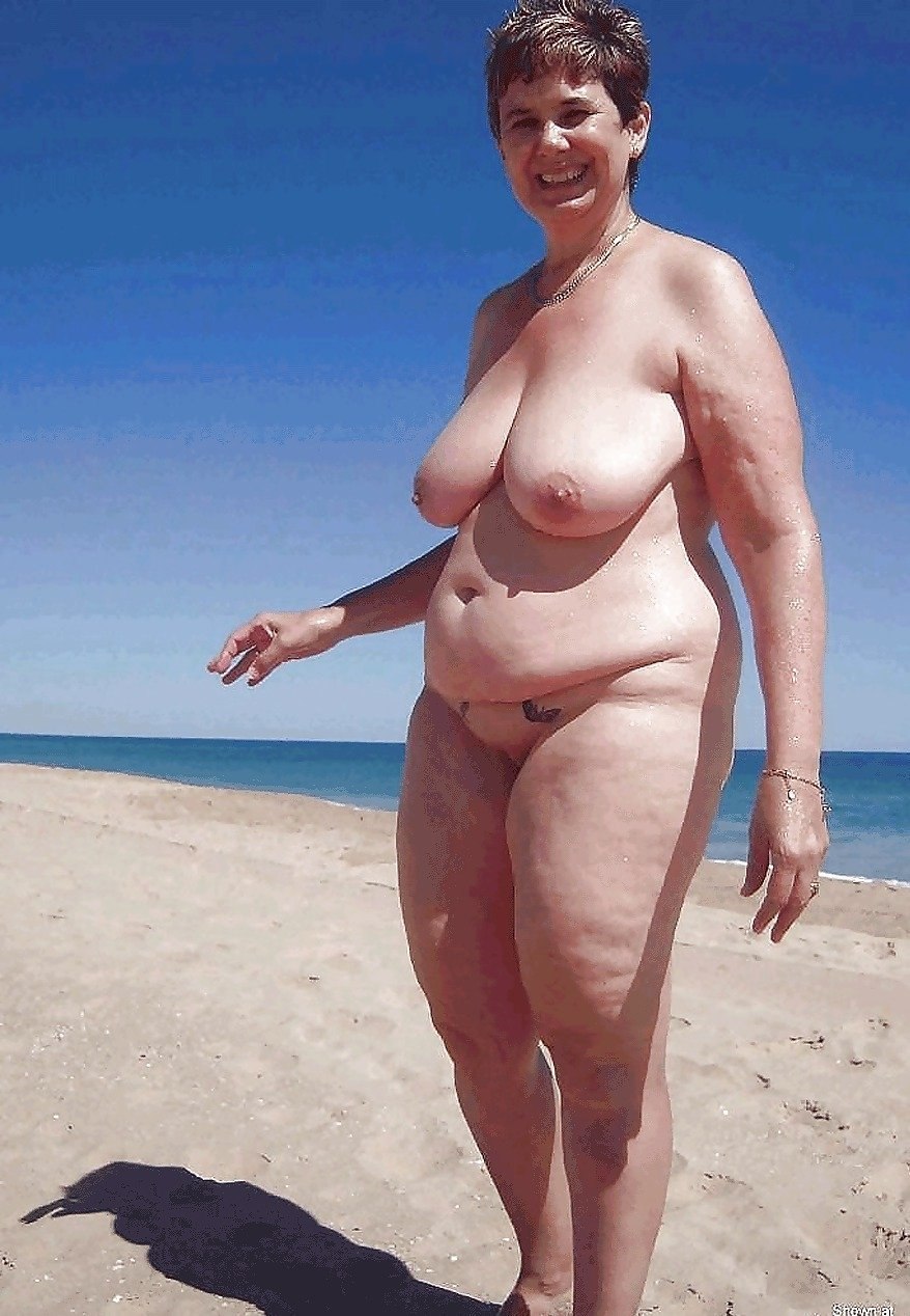 A lush naked lady on the beach sunbathes