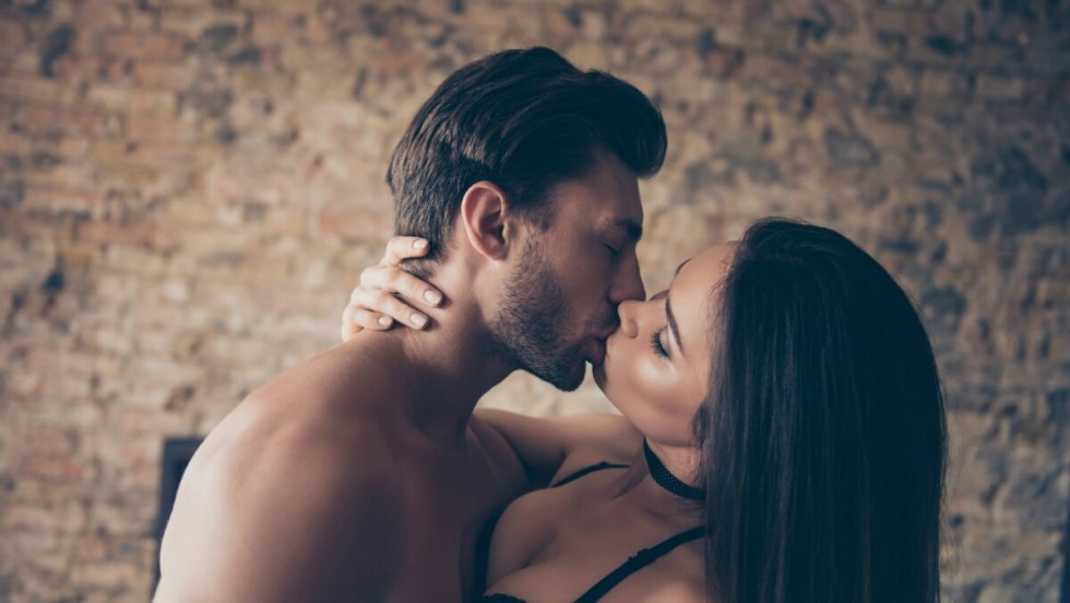 The couple kisses in bed