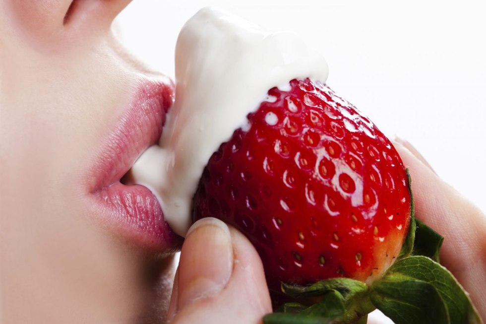 Strawberry with cream in the mouth