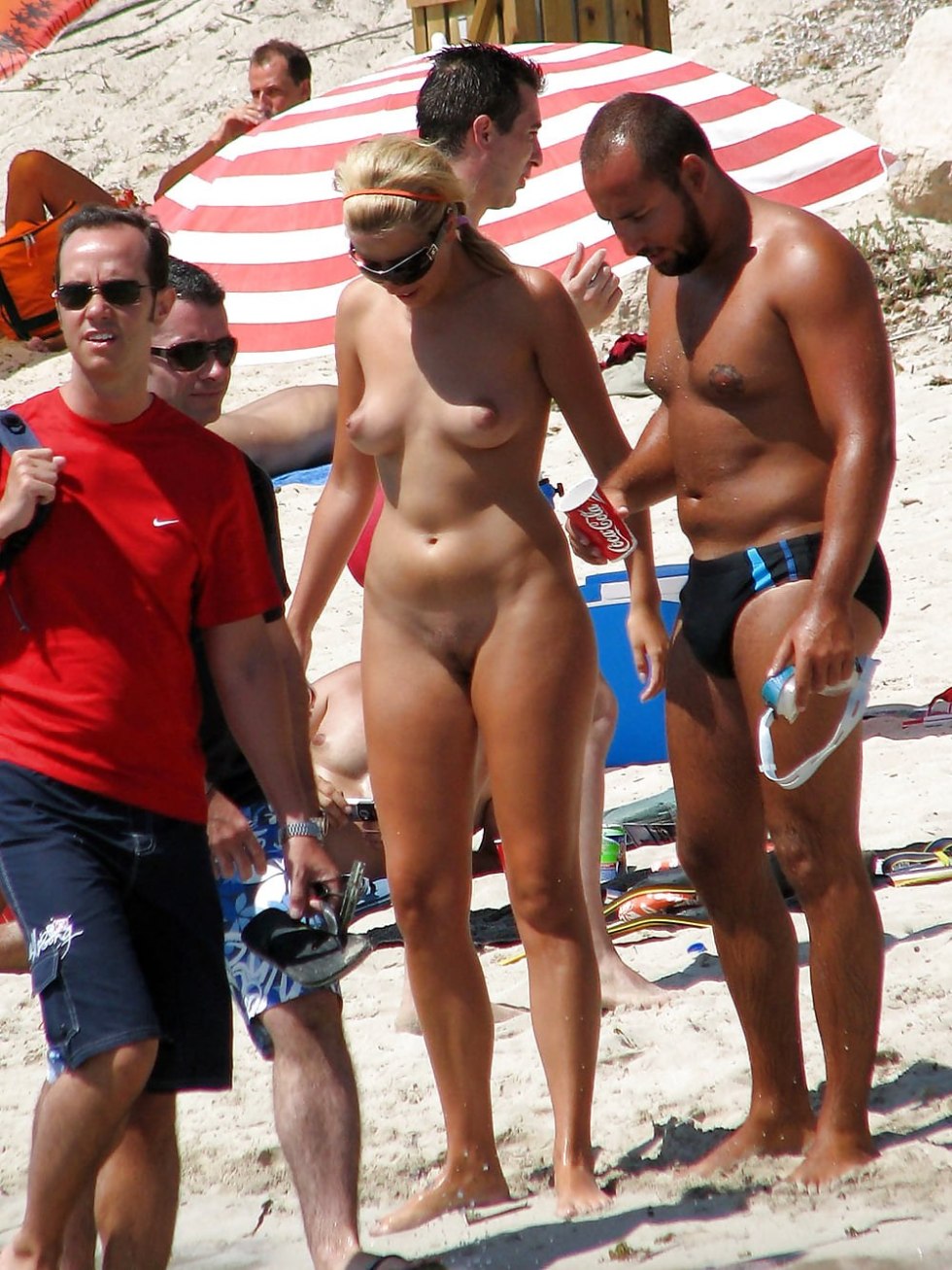 Naked women among men on the beach