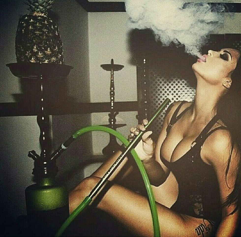 The woman smokes a hookah